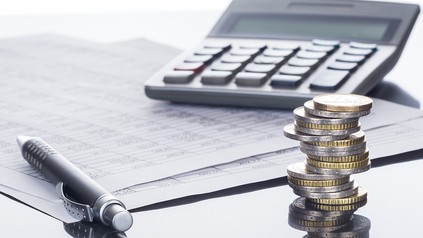 Geld, Stift, Block und Taschenrechner