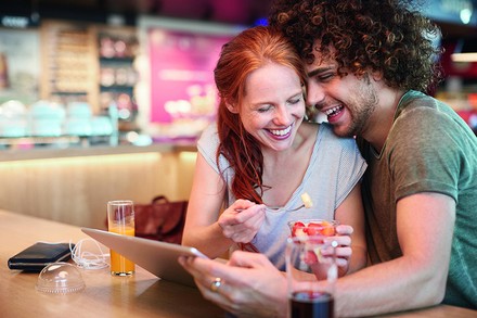 Ein glückliches Päärchen an einem Tisch in einem Tankstellenshop