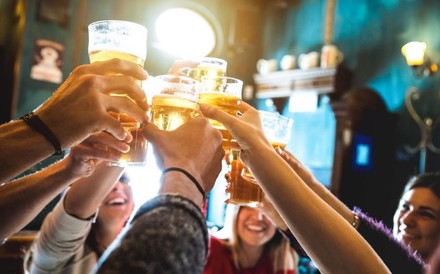 Gruppe von Freunden stößt in einer Bar mit Bier an