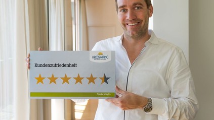Manfred Kröswang hält Schild mit Kundenzufriedenheit hoch
