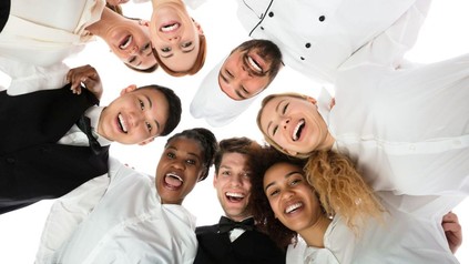 Junge Köche und Kellner lachen