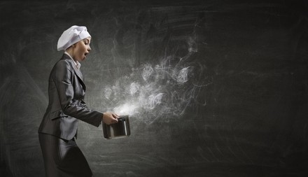 Köchin hält heißen Kochtopf von sich