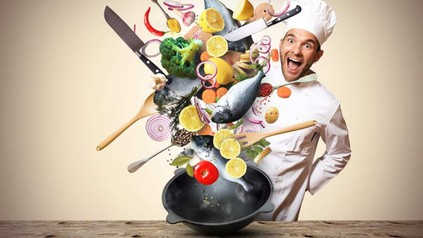 Ein lustiger Koch, der mit Lebensmitteln jongliert
