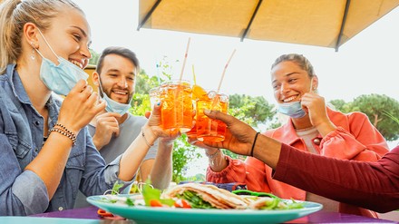 Freunde trinken Cocktail auf Restaurantterrasse