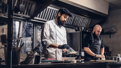 2 bärtige Köche in einer Profiküche