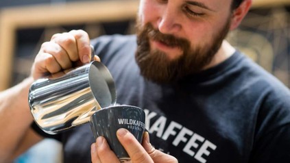 Ein Barista schenkt einen Kaffee ein