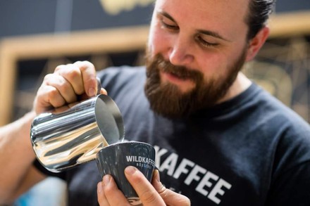 Ein Barista schenkt einen Kaffee ein