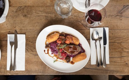 Wildgericht mit einem Glas Rotwein