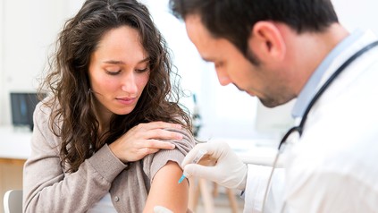 Arzt impft Patientin