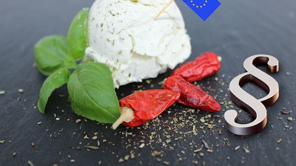 Ein Frischkäse, eine EU-Fahne und ein Paragrafenzeichen