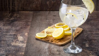 Getränk in Glas und Zitronen auf Schneidbrett