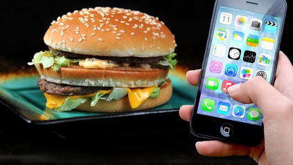 Ein Big Mac von McDonald's neben einem Smartphone