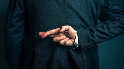 Mann kreuzt hinter seinem Rücken die Finger