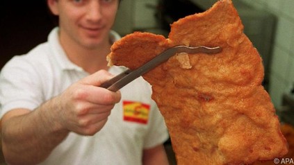 Mann mit Schnitzel in der Hand