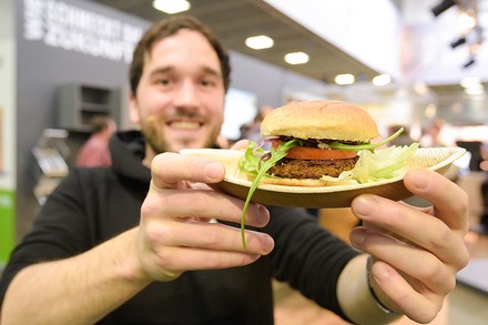 Ein junger Mann mit einem Insektenburger