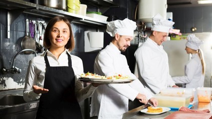 3 Köche und eine Kellnerin bei der Arbeit