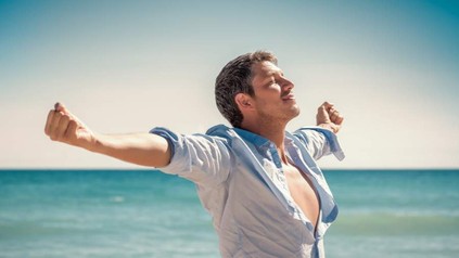 Mann streckt sich am Strand