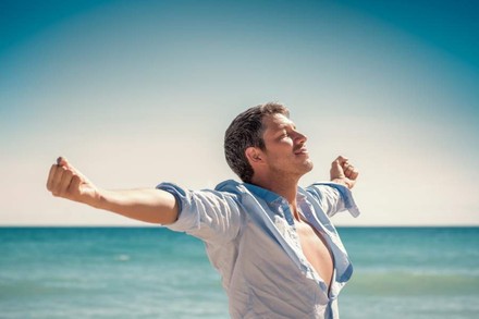 Mann streckt sich am Strand