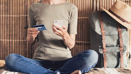 Frau mit EC-Karte und Smartphone in der Hand