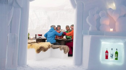 Eine Gruppe feiernder Menschen in einem Iglu