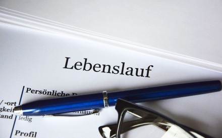 Ein Lebenslauf auf dem ein Stift und eine Brille liegen