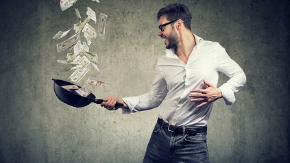 Ein Koch schwenkt eine Pfanne voller Geld