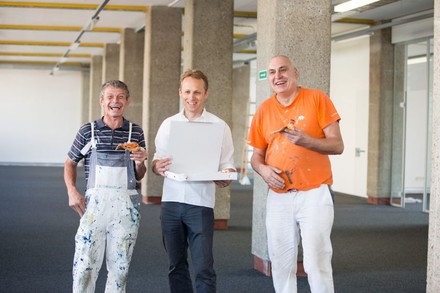 Zwei Arbeiter auf einer Linzer Baustelle freuen sich über die unerwartete Pizza-Lieferung durch Mjam-Geschäftsführer Michael Hagenau