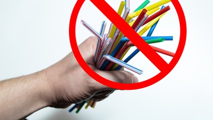 Eine Handvoll Plastikstrohhalme mit einem "Durchgestrichen"-Symbol
