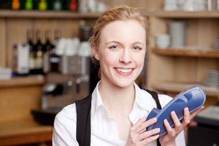 Kellnerin mit EC- und Kreditkartenlesegerät in der Hand