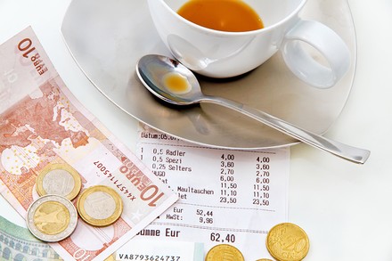 Auf einem Tisch befindet sich eine Kaffeetasse und Geldscheine