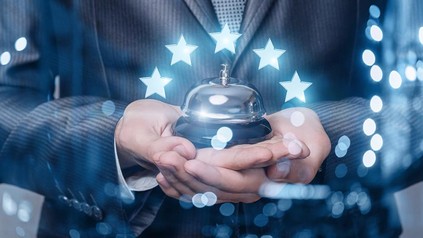 Ein Hotelier mit einer Rezeptions-Klingel