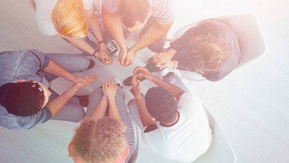 Eine Handvoll junger Menschen sitzt im Kreis und diskutiert