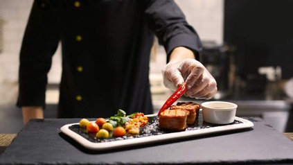 Ein Koch beim Anrichten eines köstlichen Gerichts