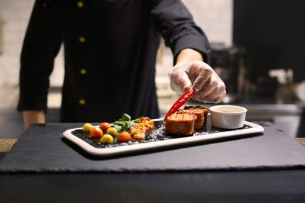 Ein Koch beim Anrichten eines köstlichen Gerichts