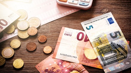 Bargeld und Taschenrechner auf dem Tisch