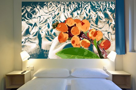 Ein Hotelzimmerbett mit einem modernen Gemälde an der Wand dahinter