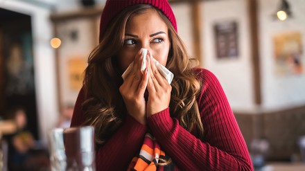 Eine Frau in einem Restaurant niest