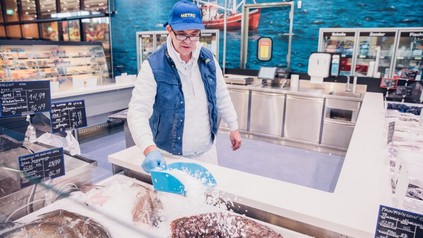 Metro-Verkäufer schüttet Eis in die Fisch-Theke