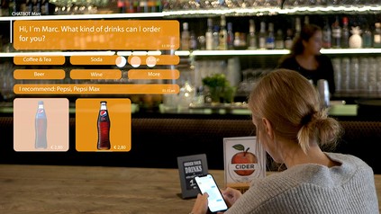 Eine Frau mit einem Handy an einer Bar