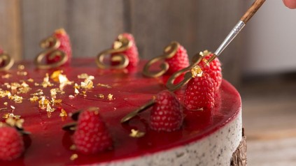 Himbeer-Torte wird mit Blattgold verziert