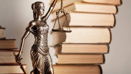 Justitia Figur vor Büchern