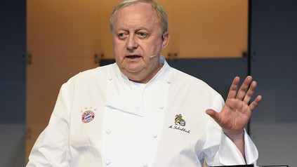 Koch Alfons Schuhbeck winkt dem Betrachter zu