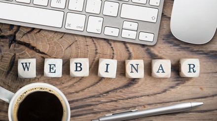 Webinar Szenebild mit Laptop Maus Kaffee und Würfeln mit Webinar als Wort