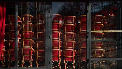 geschlossenes Restaurant von außen mit gestapelten Stühlen im Inneren