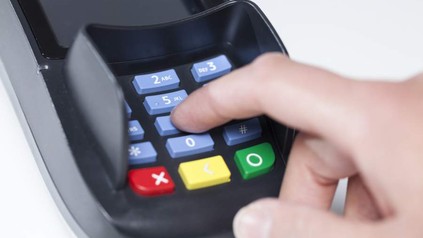 Person tippt PIN Code in EC-Karten Lesegerät