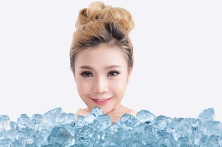 Eine Chinesin vor einem Stapel Eiswürfel