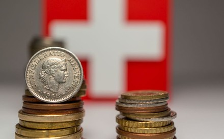 Schweizer Münzen vor einer Schweizer Fahne