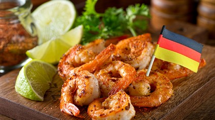 Ein teller mit gegrillten Garnelen und eine Deutschlandfahne