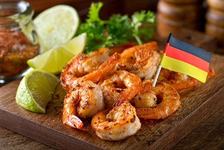 Ein teller mit gegrillten Garnelen und eine Deutschlandfahne
