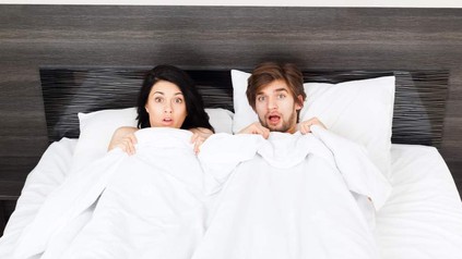 Erschrecktes Paar in Bett